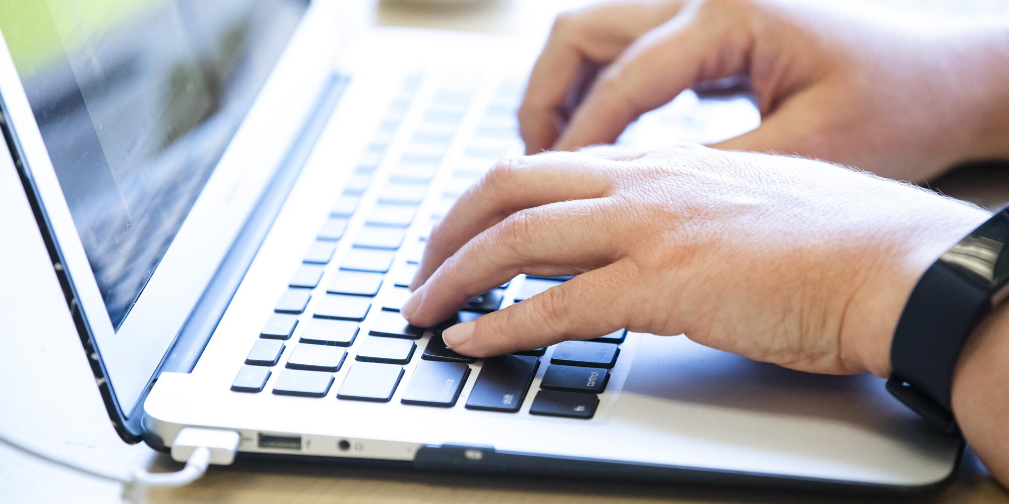 Hands typing on a computer